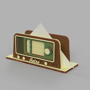 May include: A wooden napkin holder shaped like a vintage radio with a green face, brown knobs, and the word "Retro" printed on the front.