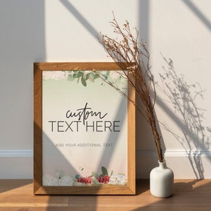 May include: A framed print with a watercolor floral design and the text "custom text here" and "add your additional text". The frame is brown wood and the print is on a light pink background.