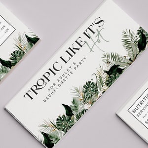 May include: A white card with green tropical leaves and the text "Tropic Like It's Hot" for Ashley's Bachelorette Party.