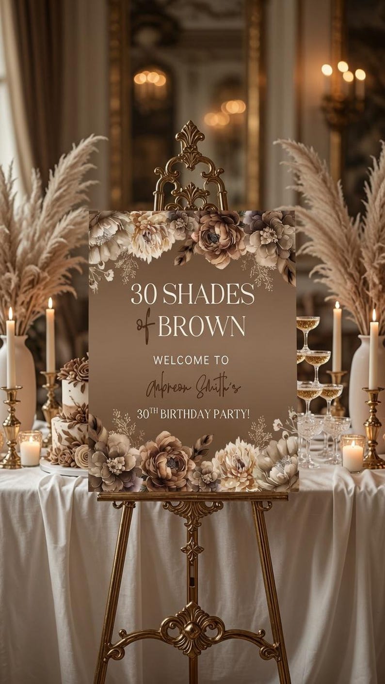 Puede incluir: Un letrero rectangular sobre un caballete dorado con ilustraciones florales marrones en la parte superior e inferior. El texto dice: 30 SHADES of BROWN WELCOME TO Anpreon Smith's 30TH BIRTHDAY PARTY! El fondo es un degradado de tonos marrones.