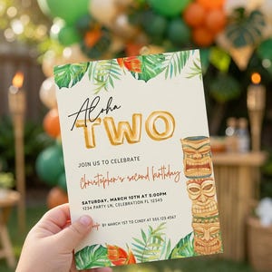 May include: A rectangular birthday invitation card with a cream background, featuring green tropical leaves, orange flowers, and a brown tiki totem pole. The text reads Aloha TWO, Join us to celebrate Christopher's second birthday, Saturday, March 10th at 5:00pm, 1234 Party Ln, Celebration FL 12345, RSVP by March 1st to Cindy at 555.123.4567.