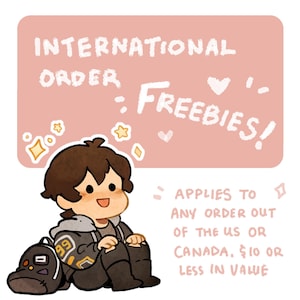 Peut inclure: Illustration de style dessin animé avec le texte "INTERNATIONAL ORDER FREEBIES!" sur fond rose. Un personnage de dessin animé est assis à côté d'un sac à dos. Le texte en dessous indique "APPLIES TO ANY ORDER OUT OF THE US OR CANADA, $10 OR LESS IN VALUE."
