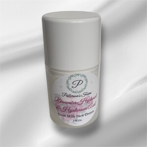 May include: A white plastic bottle with a white label. The label features a green wreath with a letter P in the centre. The text on the label reads "Patterson's Farm Rosewater Hydrosol & Hyaluronic Acid Goat Milk Face Cream 2 fl. Oz."
