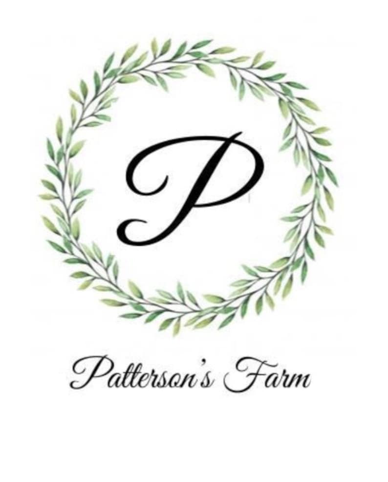 May include: A green leafy wreath with a black letter "P" in the center. The text "Patterson's Farm" is below the wreath.