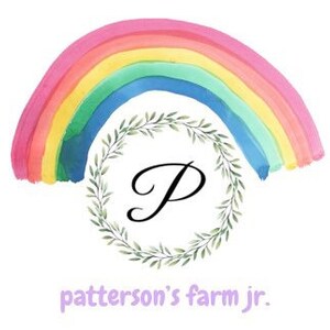 May include: A watercolor rainbow with a green wreath and the letter "P" in the center. The text "patterson's farm jr." is below the wreath.