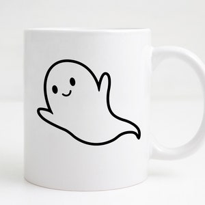 May include: White ceramic mug with a black and white cartoon ghost illustration. The ghost has a smiling face and a raised arm. The mug has a curved handle and is suitable for hot or cold drinks.