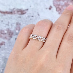 May include: Three delicate gold bands with a row of marquise-shaped diamonds set in each band.