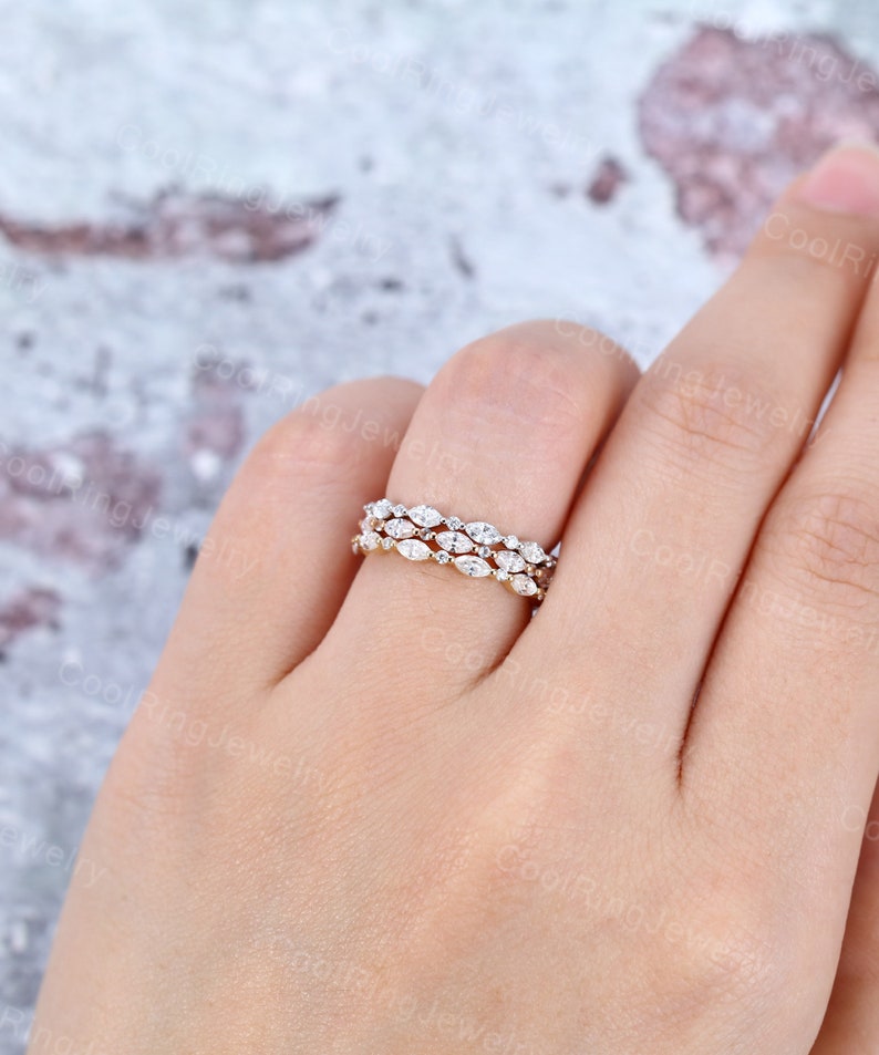 May include: Three delicate gold bands with a row of marquise-shaped diamonds set in each band.