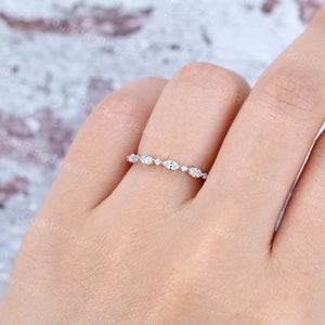 May include: A delicate silver band with a row of small, round and marquise-shaped diamonds.