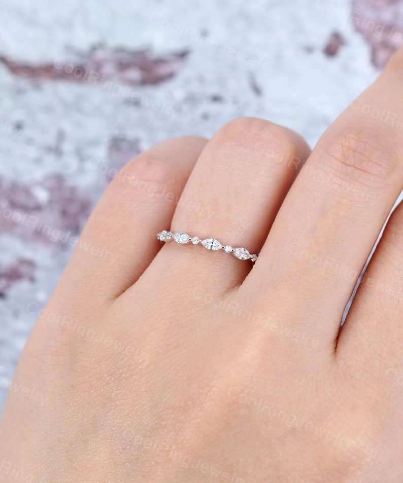 May include: A delicate silver band with a row of small, round and marquise-shaped diamonds.