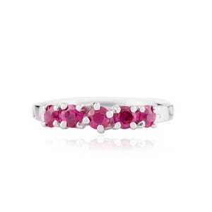 Puede incluir: Un anillo de plata con seis gemas de rubí rojo brillante en una fila. Los rubíes son redondos y están muy juntos, creando una línea continua de color. La banda del anillo es de plata pulida.