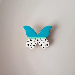 Broche de madeira com bolinhas e borboleta azul pintada à mão