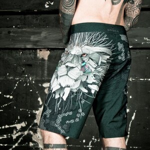 May include: Black and green athletic shorts with a white lion graphic print. The lion has a geometric design and a detailed face.