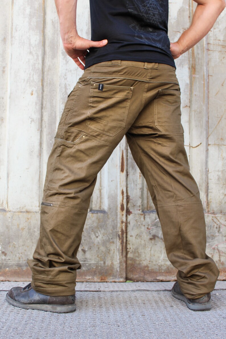 May include: A pair of brown cargo pants with multiple pockets and a zipper detail on the leg. The pants are made of a durable, cotton-blend fabric.