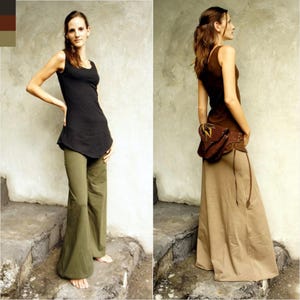 May include: Two women wearing different styles of trousers. The woman on the left is wearing a black tank top and olive green wide-leg trousers. The woman on the right is wearing a brown tank top and a long, beige skirt.