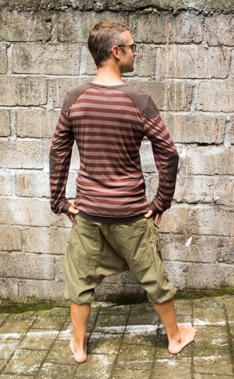 May include: A person wearing a brown and white striped long-sleeved shirt with brown elbow patches and khaki cargo pants.