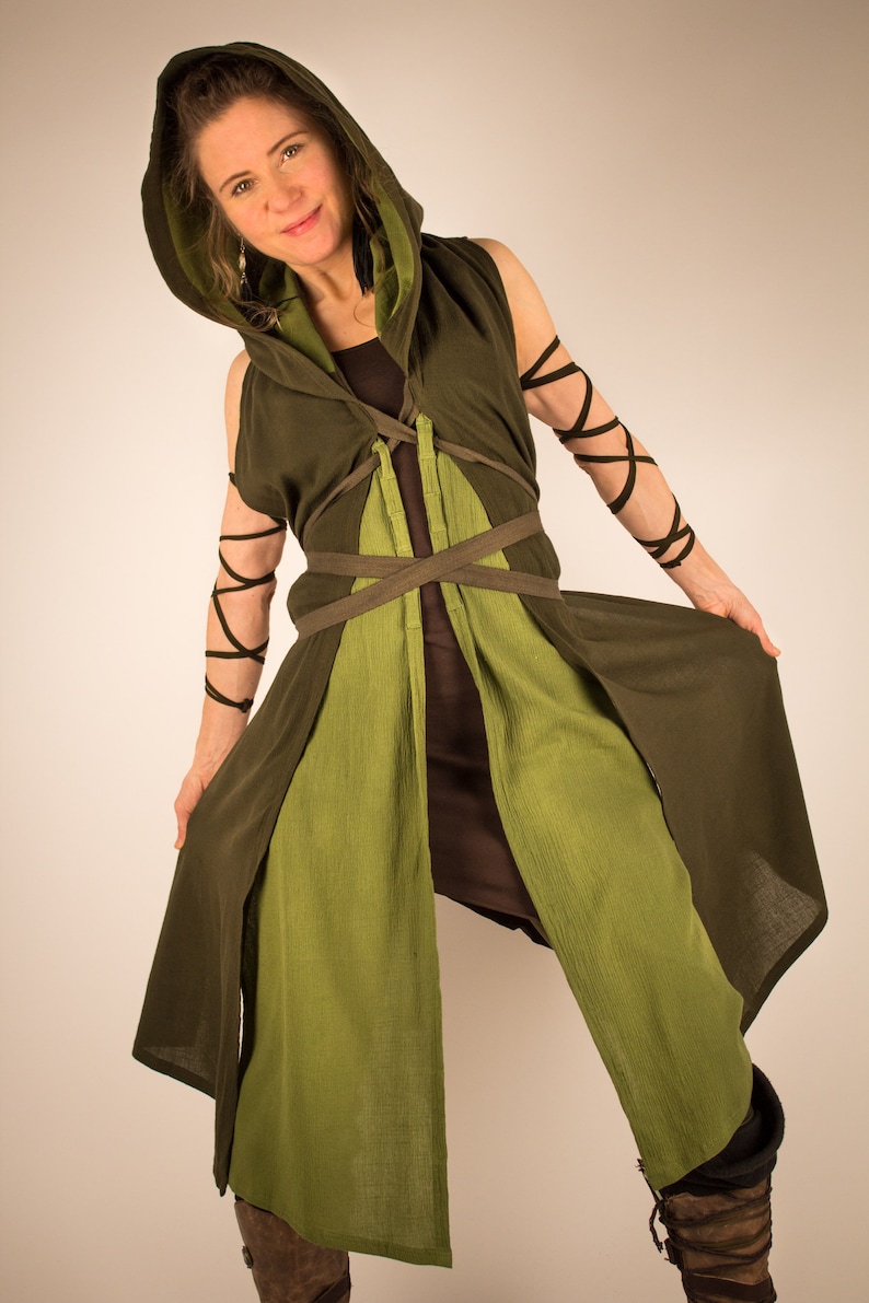 May include: A green hooded tunic with brown straps and a brown undergarment. The tunic has a long, flowing design and is tied at the waist with a brown belt.