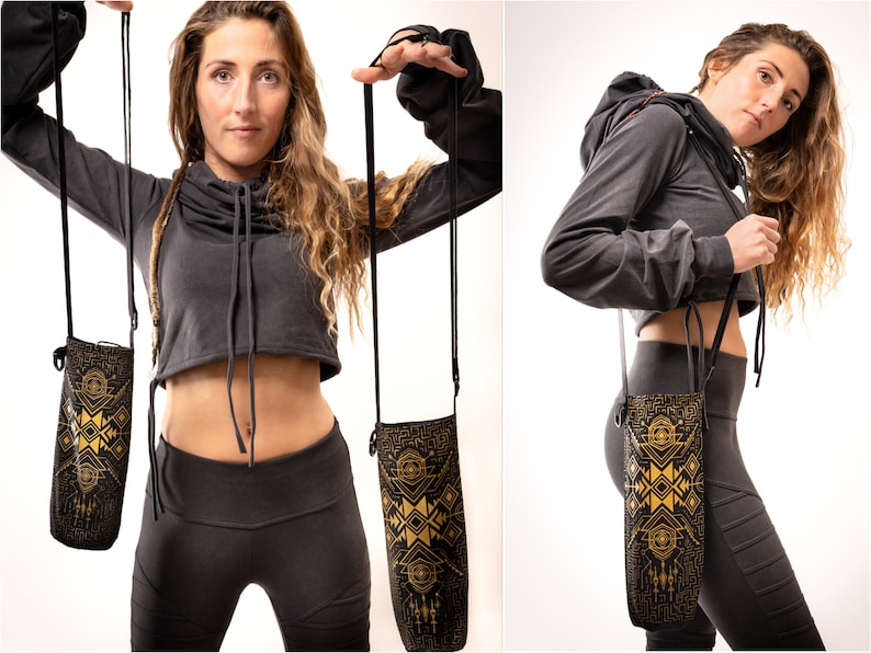 May include: Black water bottle holder with a gold geometric design. The holder has a long black strap for carrying. The design features a series of geometric shapes and patterns. The holder is shown in two different views.