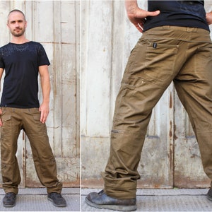 May include: A pair of brown cargo pants with multiple pockets and a zipper detail on the side. The pants are made of a durable, cotton-blend fabric.
