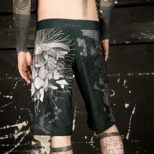May include: Black and white patterned swim trunks with a graphic print of a lion's face. The trunks have a geometric pattern and the lion's face is stylized with a futuristic design.