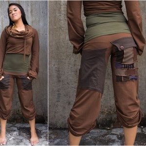Può includere: Top corto marrone con scollo a lupetto e maniche lunghe. Pantaloni marroni con un design a patchwork e un cordoncino in fondo.