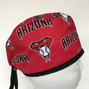 May include: Red and black surgical scrub hat with a repeating pattern of the Arizona Wildcats logo, which features a cartoon snake with a baseball in its mouth. The text "Arizona" is repeated throughout the pattern.