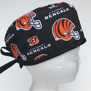 May include: Black scrub hat with a repeating pattern of orange and black tiger helmets and the text "Cincinnati Bengals".