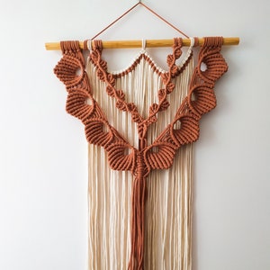 Hanging wall macrame in brick and ecru  in a boho style. Macrame wall art for interior
