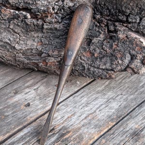 May include: A white ceramic mug with a black handle and the text "But First, Coffee" in a bold, black font. The mug is sitting on a wooden surface. The mug is approximately 4 inches tall.