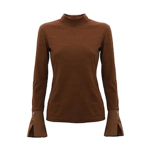 May include: A brown long-sleeved shirt with a mock neck and bell sleeves. The sleeves have a button detail.