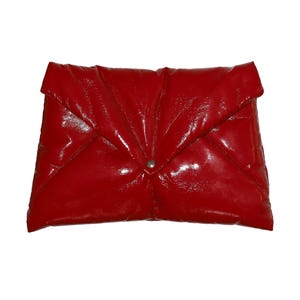 May include: A red patent leather clutch with a quilted design.