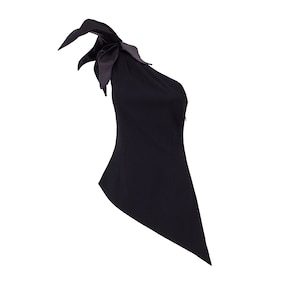 May include: A black one-shoulder top with a single, large bow detail on the shoulder strap. The top is fitted and has a slightly asymmetrical hemline.