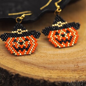 Könnte beinhalten: Ein Paar Halloween-Ohrringe mit orangefarbenen, schwarzen und goldenen Perlen-Kürbisgesichtern mit Hexenhüten.