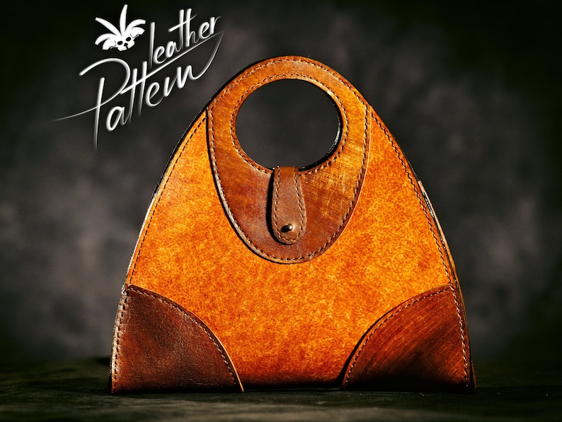 May include: A brown leather handbag with a triangular shape and a circular handle. The bag has a textured surface and is made of multiple pieces of leather.