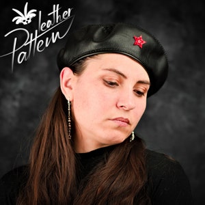 Puede incluir: Un gorro de cuero negro con una estrella roja en el lateral. El gorro lo lleva una persona con el pelo largo y castaño.