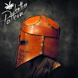 May include: A brown leather helmet with a visor, featuring a horizontal eye slit and circular ventilation holes on the side. The helmet is constructed from multiple leather panels joined by brass-colored metal rivets. The text Pattern Leather is visible.