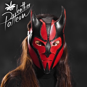 May include: A red and black leather mask with horns. The mask has eye holes and a pointed chin.