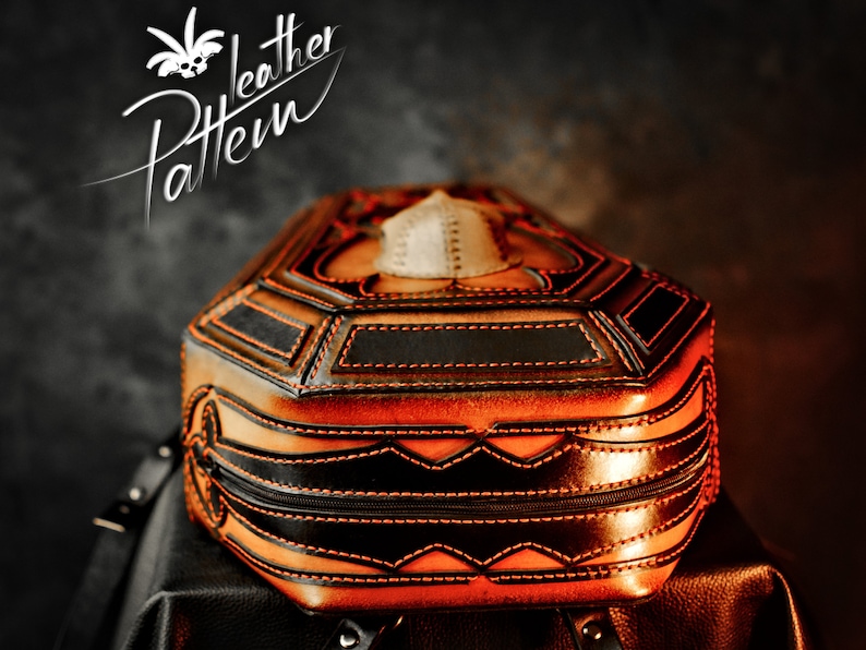 May include: A brown leather backpack with black and orange stitching. The backpack is shaped like a coffin and has a skull design on the front.