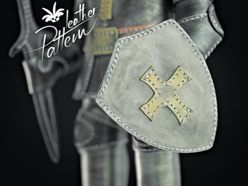 Puede incluir: Primer plano de un escudo y armadura de caballero medieval. El escudo es gris con un dise&ntilde;o de cruz amarilla y costuras blancas. La imagen incluye el texto "Leather Pattern".