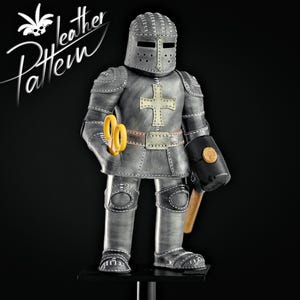 Puede incluir: Figura de caballero de cuero gris hecha a mano con casco, tijeras amarillas y un martillo negro. El caballero tiene una cruz blanca en el pecho y un cintur&oacute;n decorativo. Las palabras "leather Pattern" est&aacute;n en la esquina superior izquierda.