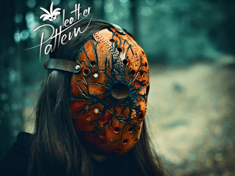 A close up portrait of a woman in the woods, wearing a handcrafted creepy leather Halloween mask