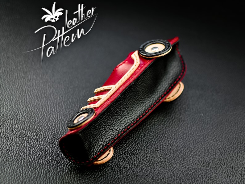 K&ouml;nnte beinhalten: Handgefertigte Ledertasche in Form eines Autos, mit rotem, schwarzem und beigem Leder. Die Tasche hat schwarze R&auml;der, rote N&auml;hte und den Text "Leather Pattern". Zum Aufbewahren kleiner Gegenst&auml;nde.
