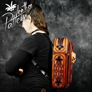 May include: A brown leather backpack with intricate black stitching and a decorative skull design. The backpack has a flap closure and a zipped pocket on the front.