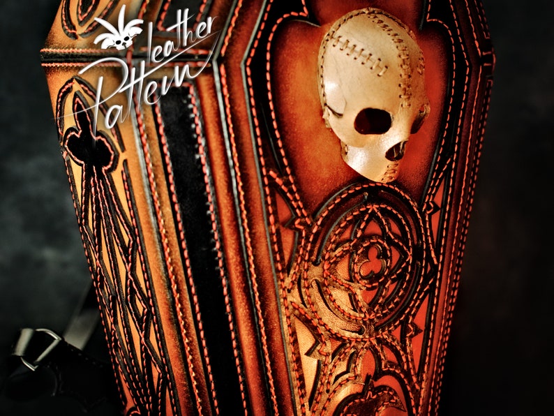 May include: A brown leather bag with intricate stitching and a skull design. The bag has a strap and is decorated with a skull with stitched details. The bag is made of leather and has a dark brown colour.