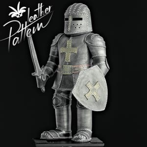 Puede incluir: Figura de caballero artesanal en cuero gris met&aacute;lico, con casco, armadura, escudo y espada. El escudo y la armadura presentan dise&ntilde;os de cruces. El texto "leather Pattern" est&aacute; en la esquina superior izquierda.