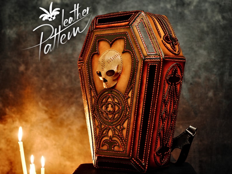 May include: A brown leather backpack shaped like a coffin with red stitching and a skull design. The backpack has a black strap and is decorated with intricate patterns.
