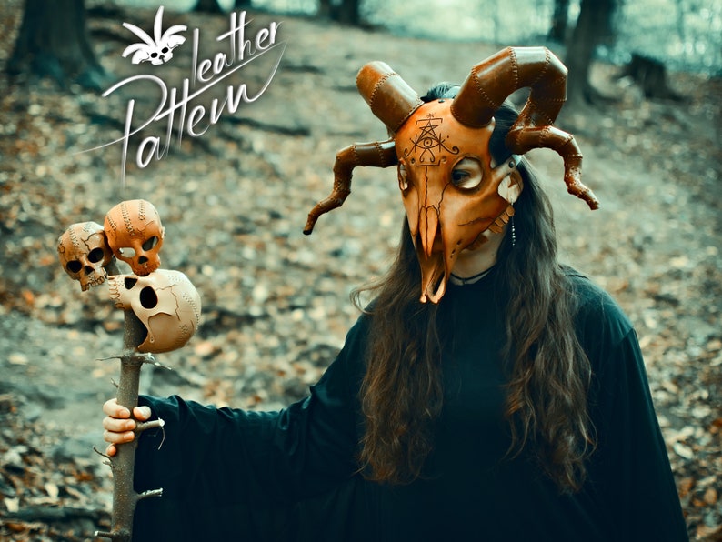 A cultist woman robed in black, wearing a horned animal skull mask made out of leather in the style of esoteric symbolism, dark orange and beige, imitating burnished bone and holding a staff adorned with human skulls made out of leather