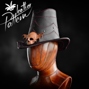 Könnte beinhalten: Ein schwarzer Lederhut mit rotem, genähten Rand und einem Totenkopf- und Fledermausdesign. Der Hut sitzt auf einem hölzernen Mannequin-Kopf.
