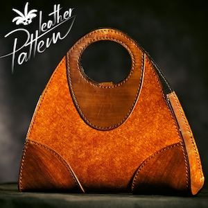 May include: A triangular leather handbag with a brown and tan color scheme. The bag has a unique circular handle and is stitched with brown thread.