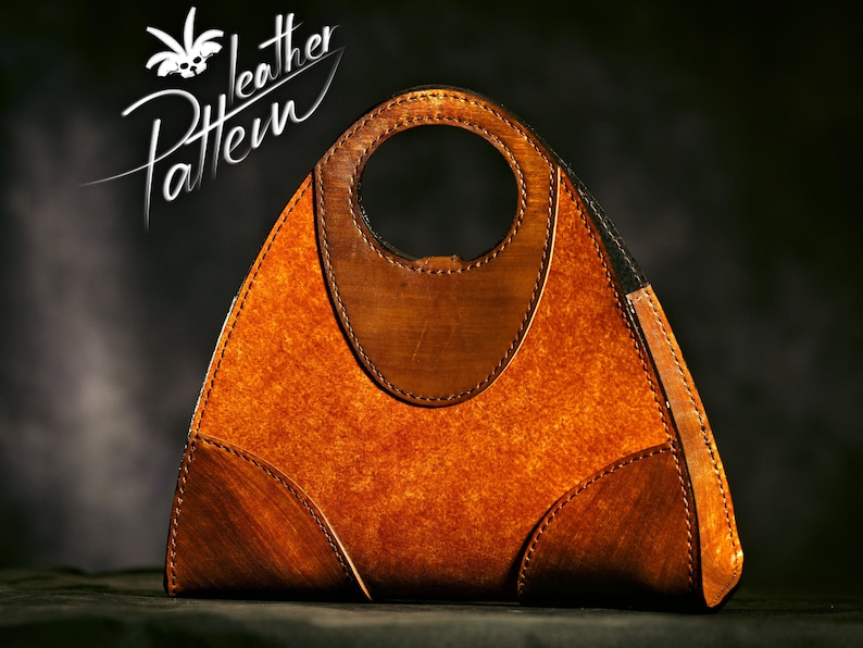 May include: A triangular leather handbag with a brown and tan color scheme. The bag has a unique circular handle and is stitched with brown thread.